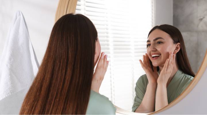 Mulher se cuidando em frente ao espelho
