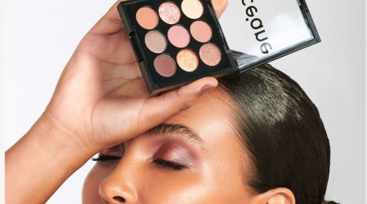 Modelo com maquiagem glow segurando paleta de sombras Pocket Nude Océane