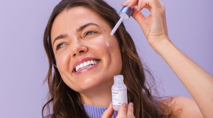 modelo aplicando sérum com fito-retinol