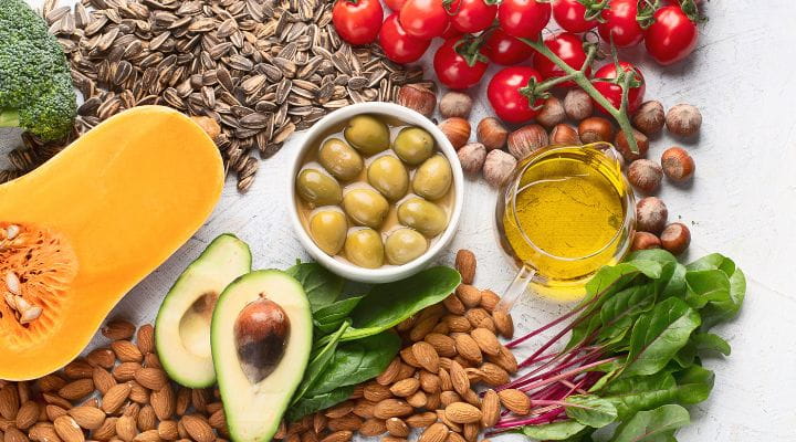 Foto de frutas, legumes, amêndoas, sementes e outros alimentos que contêm vitamina E.