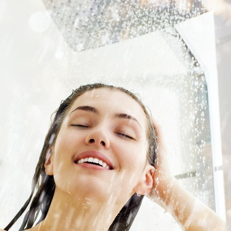 Foto do rosto de uma mulher tomando um banho gelado.