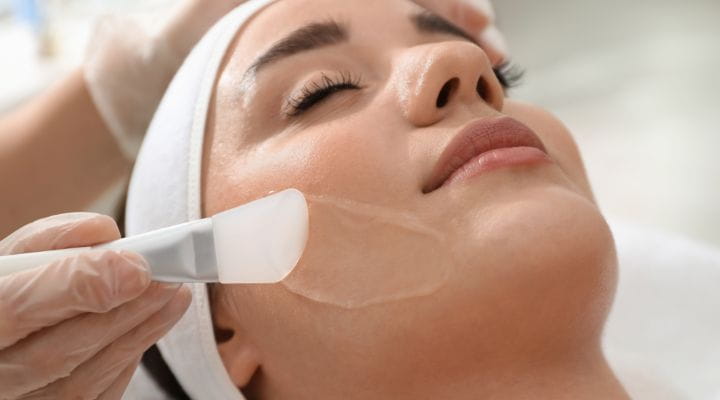 Foto de uma mulher realizando o peeling químico facial.