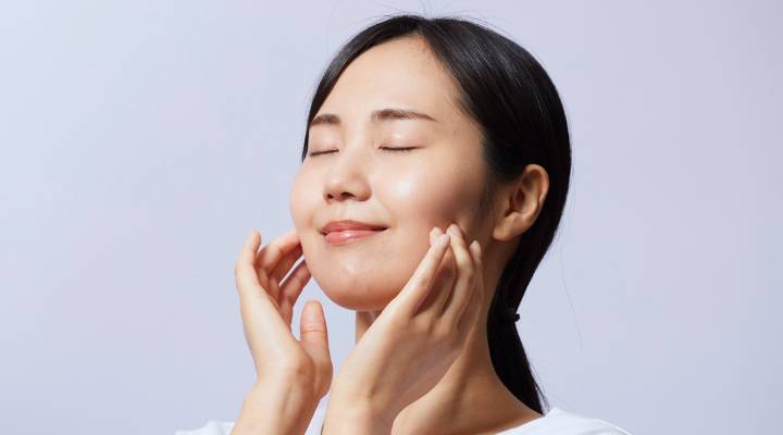 moça passando produto no rosto
