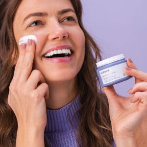 mulher passando creme hidratante Océane na face