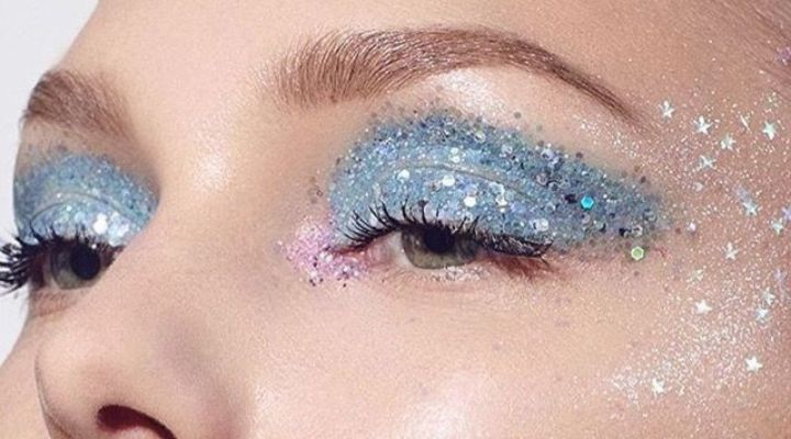 mulher usando maquiagem azul com glitter