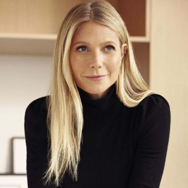 Atriz Gwyneth Paltrow com cabelo liso, loiro e longo usando blusa de gola alta preta