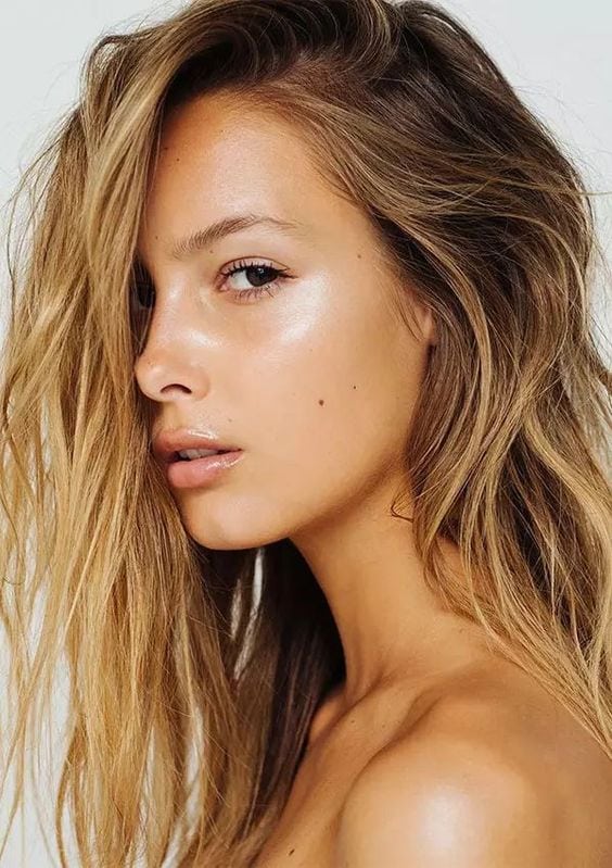 Mulher com make extremamente leve e iluminada na maça do rosto e boca