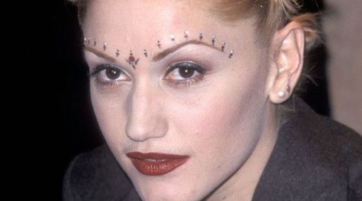 Gwen Stefani com maquiagem dos anos 2000, com base super clara e strass na testa