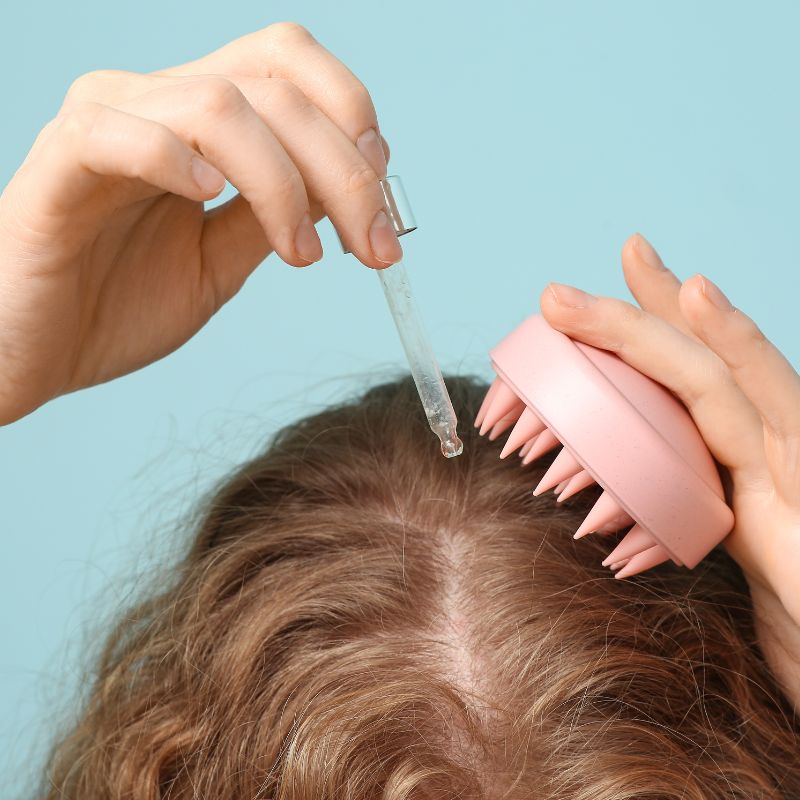 mulher aplicando produto no cabelo