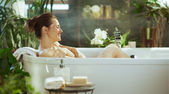 Mulher relaxando em banheira com plantas ao redor