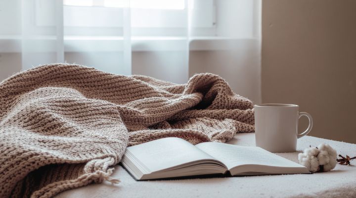 Capa de livro aberto ao lado de uma xícara