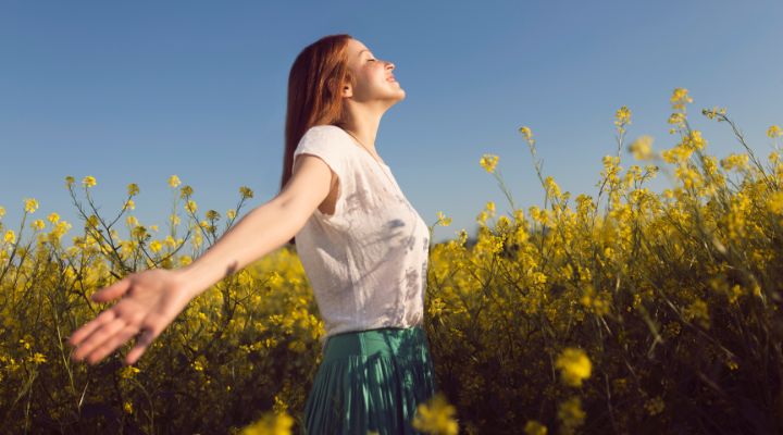 Mulher sorridente em campo de flores amarelas