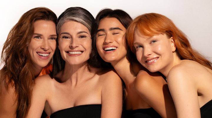 Quarteto de mulheres sorridentes em fundo claro