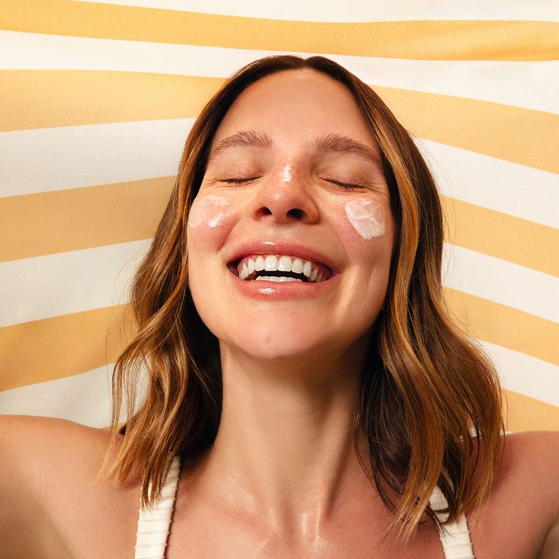 Modelo feminina com protetor solar no rosto