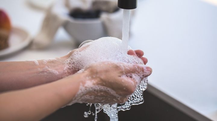 Lavando as mãos com sabão na pia da cozinha