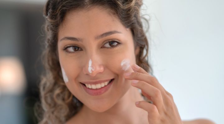 Mulher aplicando creme hidratante no rosto