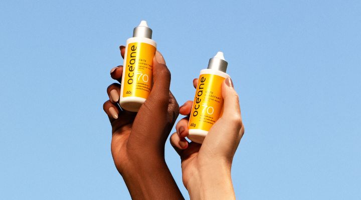 Duas mãos segurando protetores solares Oceane