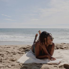 mulher deitada na areia na praia