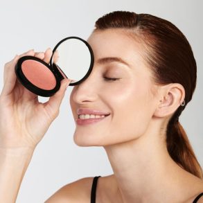 Modelo segurando o blush Glossy Edition próximo ao rosto