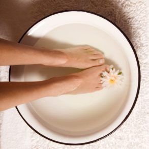 pessoa com os pés em uma bacia para realizar o escalda pés