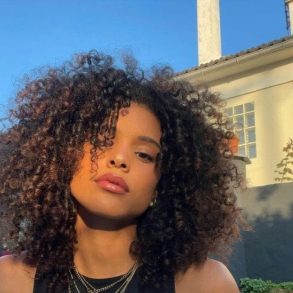 Mulher com cabelo crespo balck power e semblante sério posando para a câmera