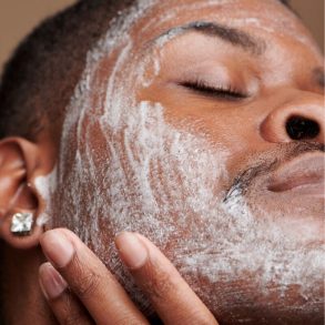 Homem aplicando produto para limpeza facial.